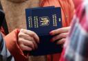 A woman holds Ukrainian passports as she waits to register in Poland.