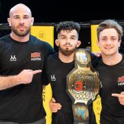 Charlie Falco with his Cage Warriors Academy straw-weight title and coaches Jack Mason and Leigh Mitchell