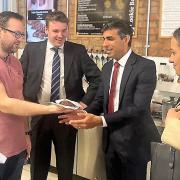 Chancellor Rishi Sunak is given a cookie during his visit by Ben Stamp during his visit to the Ipswich Microshops - watched by Tom Hunt and Economic Secretary to the Treasury Helen Whatley.