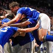 Town players celebrate with a hidden Lee Evans after his hat-trick in Ipswich Town's 6-0 win over Doncaster Rovers