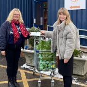 A Gatehouse food bank representative receiving the donation from Eve Hudson, a trainee solicitor at Ellisons.