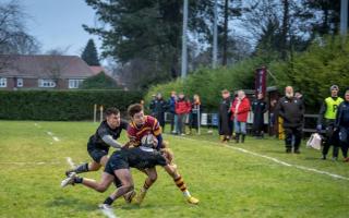 Ipswich YM wing Ed Parkin is tackled by two Holt players in their clash at the weekend