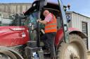 Andrew Francis applies a UK Power Networks overhead cables warning sticker to a tractor cab