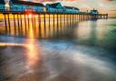 Sunburst through Southwold Pier, one of the tourist attractions in East Suffolk