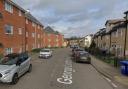 A road was shut after a fire broke out in the first floor of a block of flats