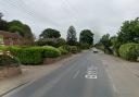 A woman was taken to hospital and a road was closed after a two-car crash near a Suffolk town. 