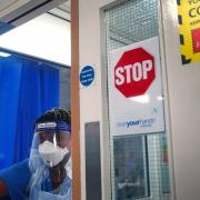 A member of staff wearing PPE walks through a ward for Covid patients at King's College Hospital, in south east London