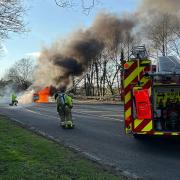 Firefighters tackling a car blaze in Hatfield Peverel were endangered when a motorist drove straight past the incident