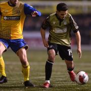 Armando Dobra of Colchester United looks to get past Jake Turner of AFC Sudbury