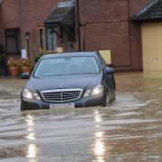 A car wades through water amid Storm Babet in Needham Market