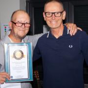 Dean Gould with his Record Holders Republic special achievement award to mark 40 years of record breaking and councillor Seamus Bennett, who presented the award on behalf of the US RHR.