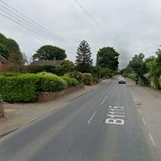 A woman was taken to hospital and a road was closed after a two-car crash near a Suffolk town. 